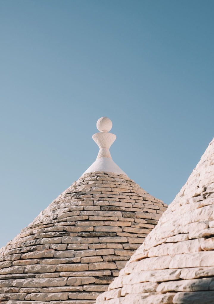 Traditional Puglian trullo rooftop against a blue sky